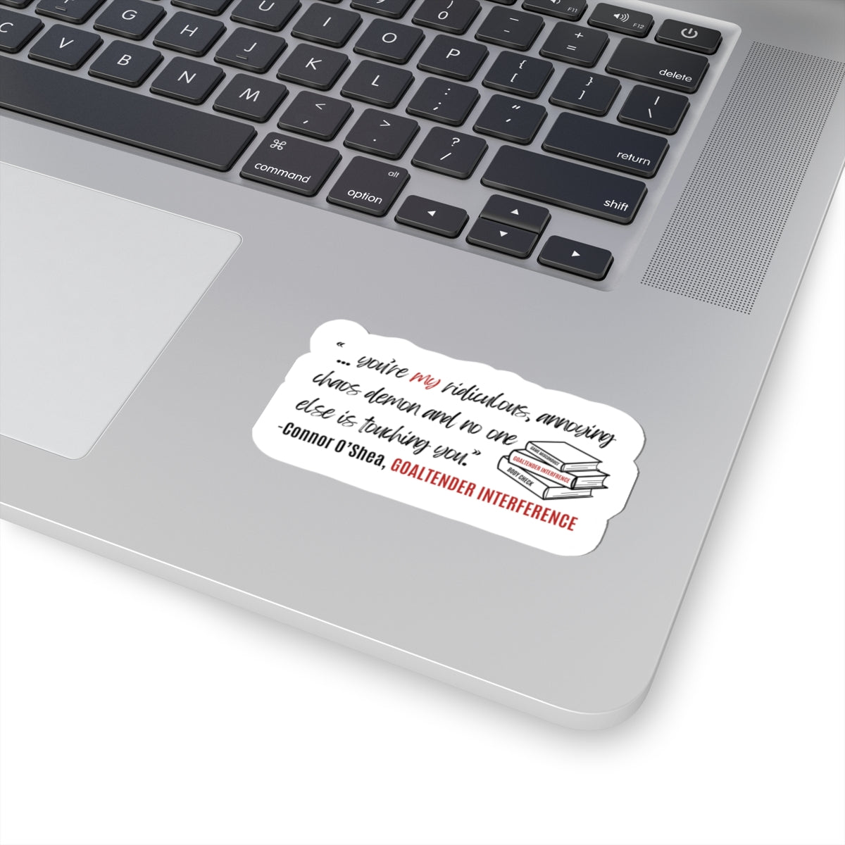 Sticker with quote by Connor O'Shea from Goaltender Interference by Brigham Vaughn with stacked books on a laptop