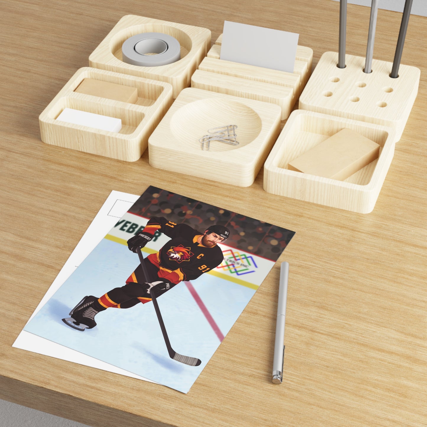 5 by 7 inch art print of illustrated Boston Harriers hockey player in action on an ice rink with a colorful background. Connor O'Shea from Goaltender Interference by Brigham Vaughn on a wooden table with a pen