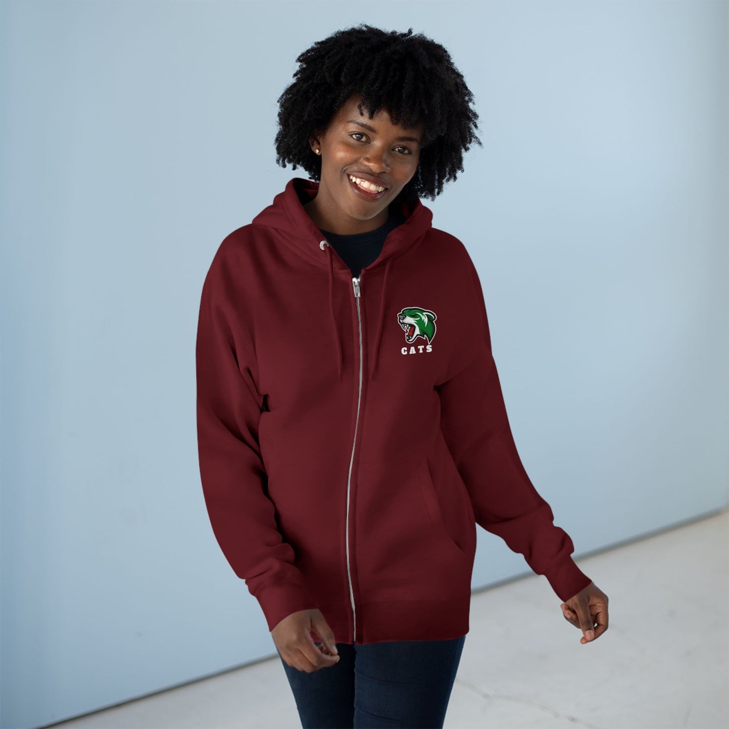 Woman with brown skin and natural black hair wearing Burgundy Noah Boucher Toronto Fisher Cats Zip Hoodie and jeans