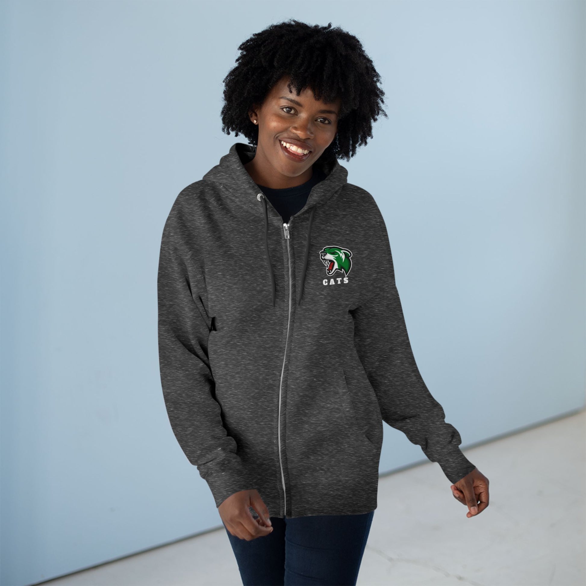 Woman with brown skin and natural black hair wearing Charcoal Grey Noah Boucher Toronto Fisher Cats Zip Hoodie with jeans.