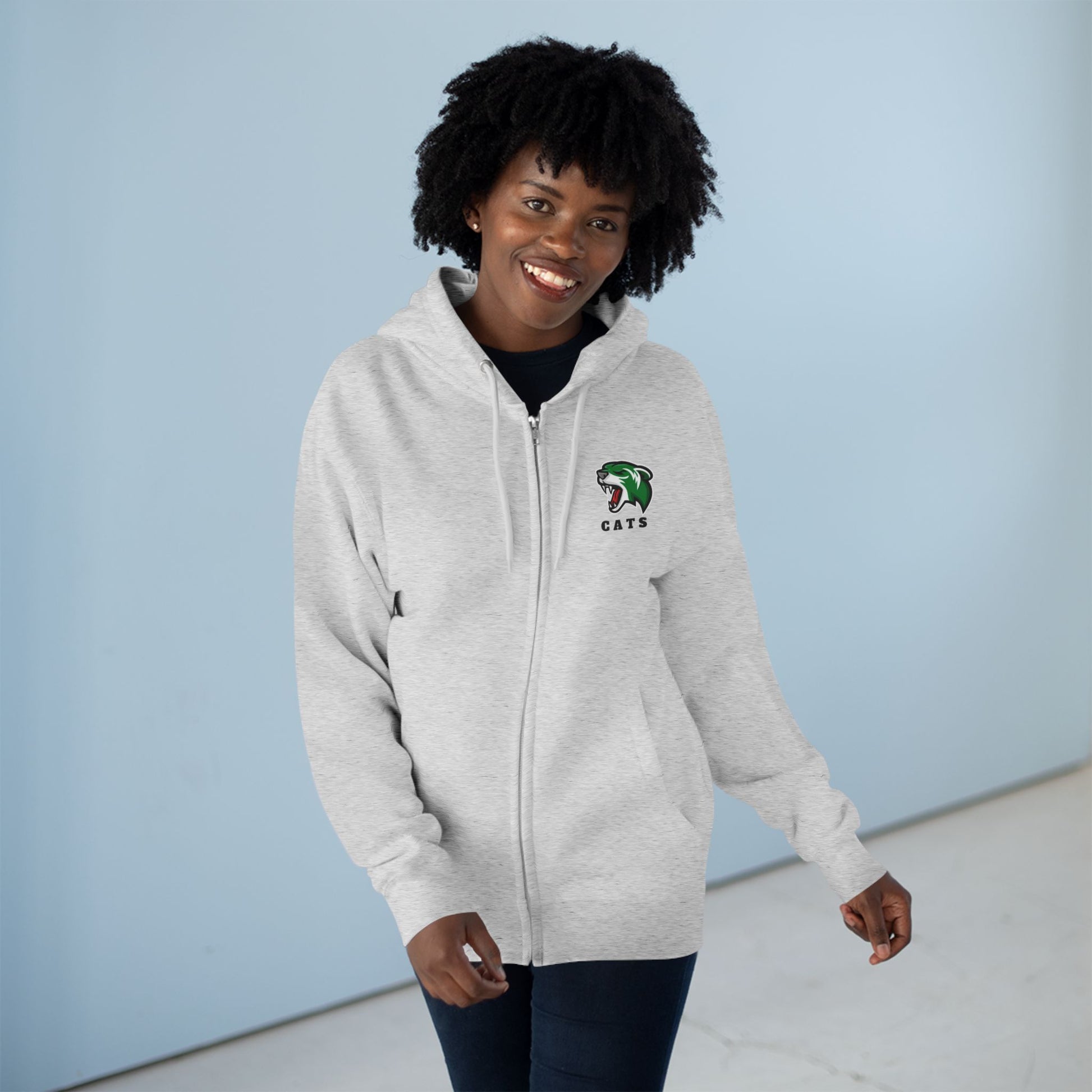 Woman with brown skin and natural black hair wearing Heather Grey Noah Boucher Toronto Fisher Cats Zip Hoodie and jeans.