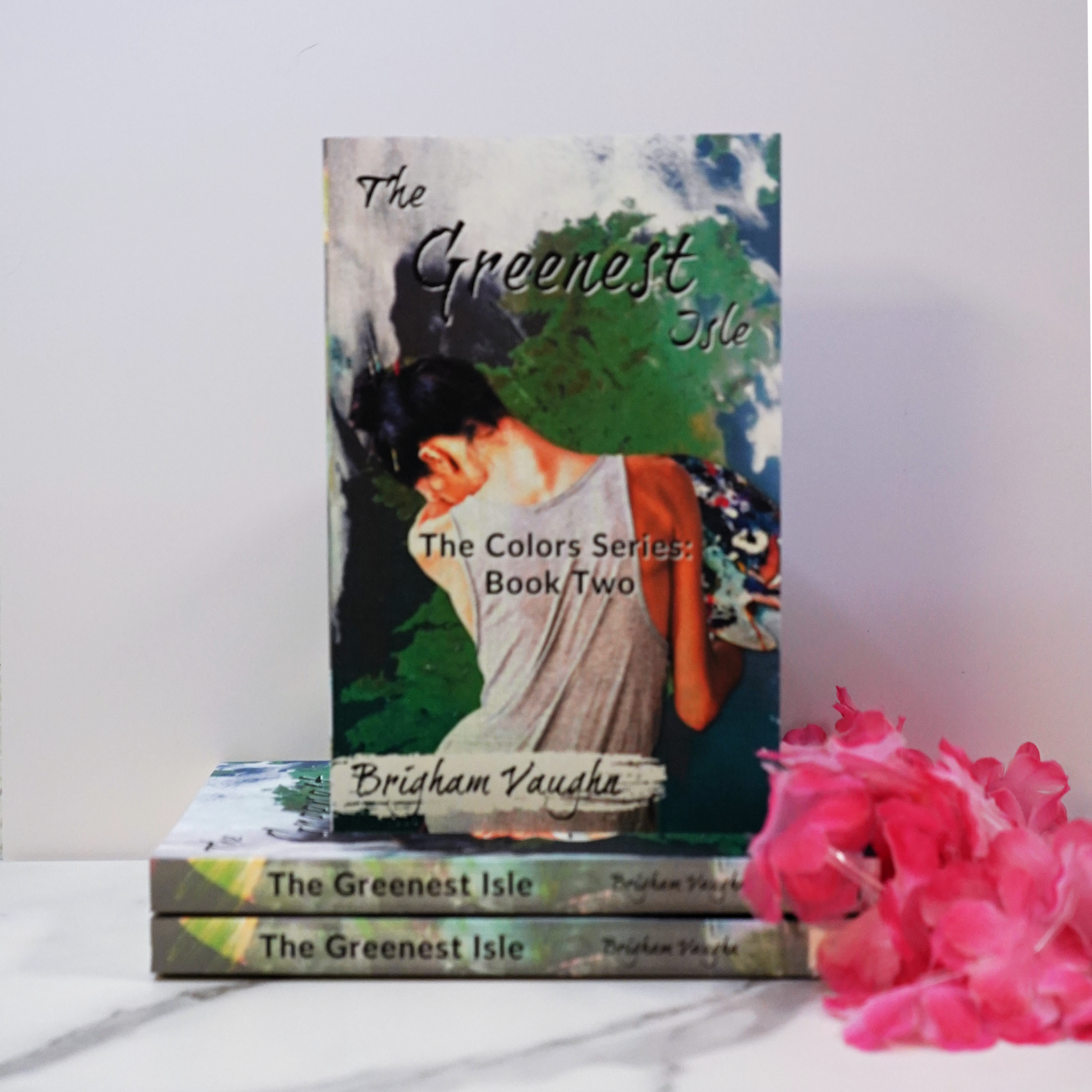Signed paperback book titled 'The Greenest Isle' by Brigham Vaughn with pink flowers on a white background. 