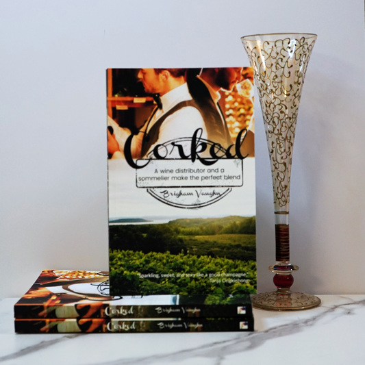 Stack of signed paperback books titled 'Corked' with a champagne flute against a white background. 