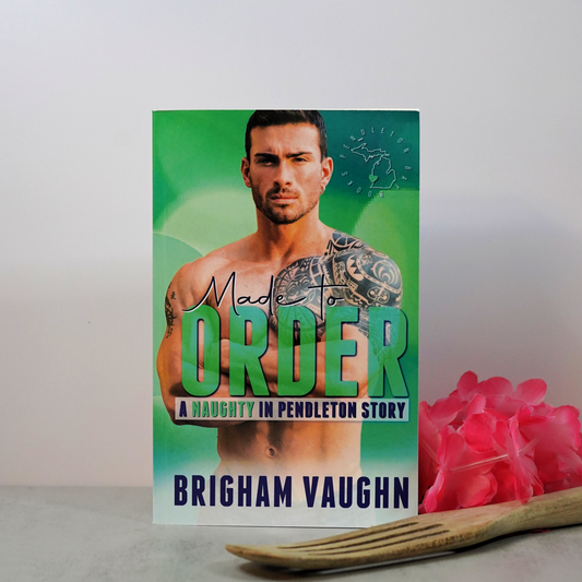 Signed paperback book cover of 'Made to Order' by Brigham Vaughn with pink flowers, and a wooden kitchen implement. 