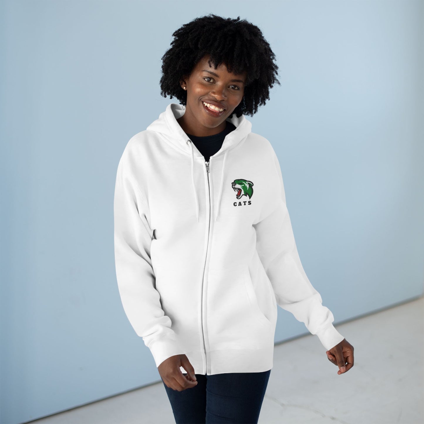 Woman with brown skin and natural black hair wearing white Noah Boucher Toronto Fisher Cats Zip Hoodie with jeans