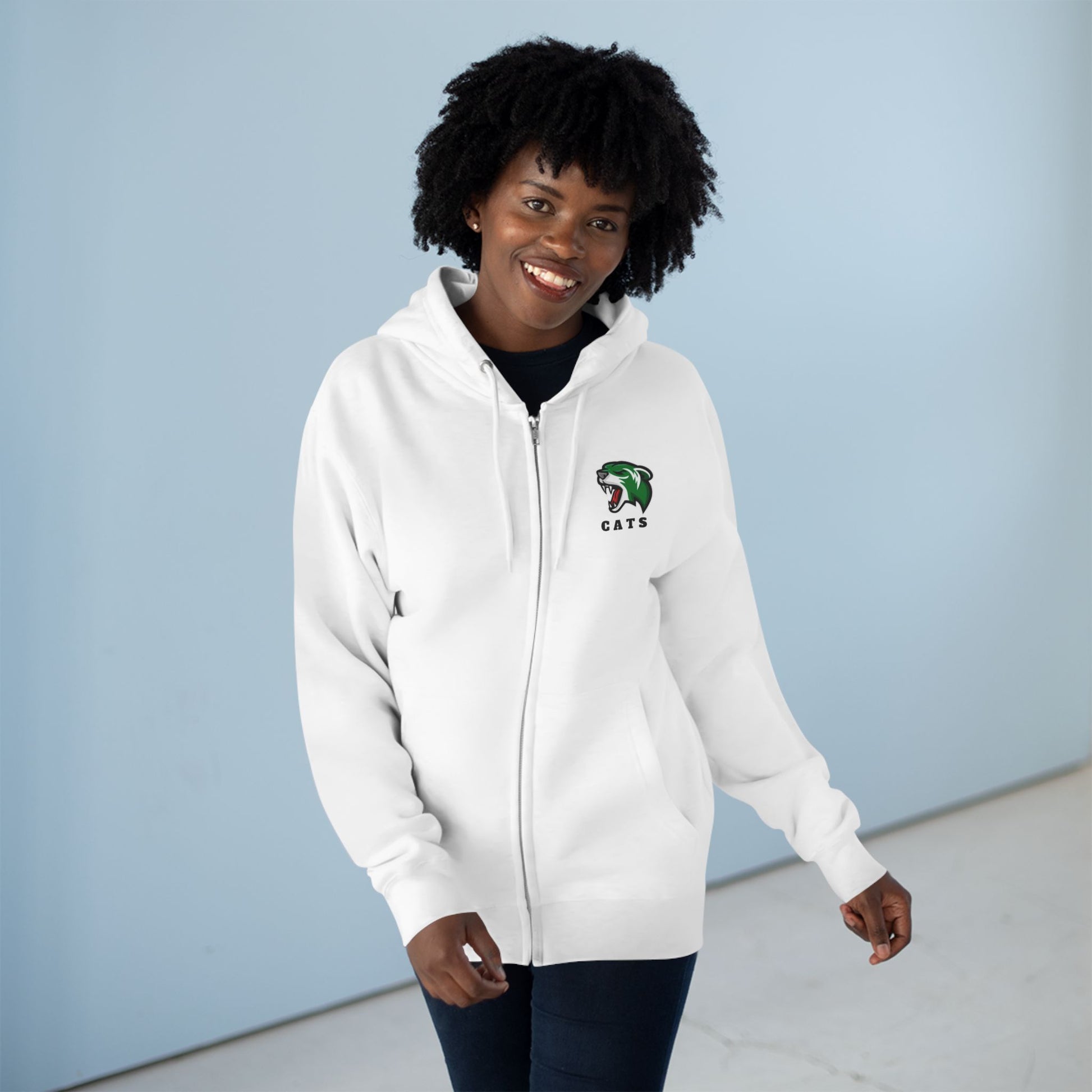 Woman with brown skin and natural black hair wearing white Noah Boucher Toronto Fisher Cats Zip Hoodie with jeans
